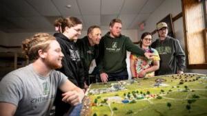 Students looking at and pointing to a diorama